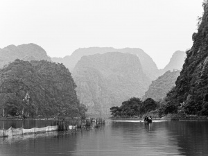 Boat-on-river-amongst-limestone-rock-formations-Ninh-Binh-Vietnam