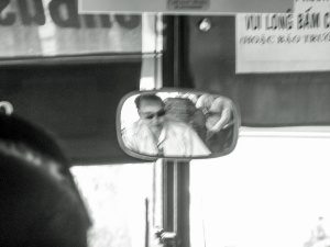 Bus-driver-looking-through-rearview-mirror-Ho-Chi-Mnih-City-Vietnam