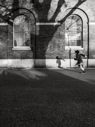 Child-running-toward-large-shadow of-tree-Saatchi-Gallery-London-England
