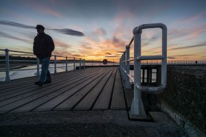 Silhouette-of-Man-Walking-on-Whitby-Pier-North-Yorkshire-Coast-England