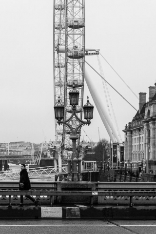 Woman-walking-past-London-eye-on-Westminster-bridge-England