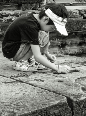 Young-boy-crouching-with-joss-sticks-Angkor-Wat-Cambodia