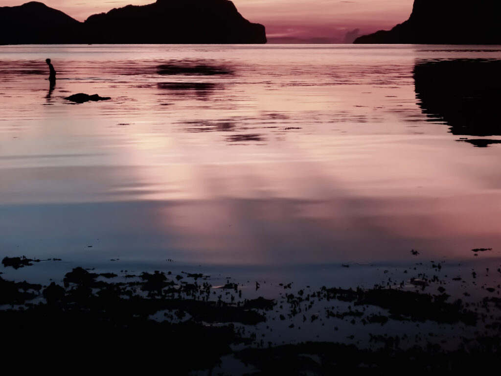 Boy wading at sunset El Nido Palawan Philippines