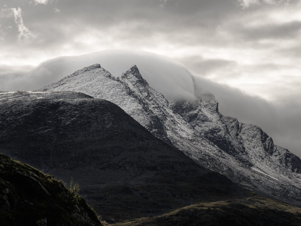 Clouds enveloping snow capped mountains Jotunheimen Norway