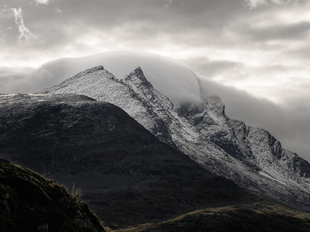 Clouds enveloping snow capped mountains Jotunheimen Norway