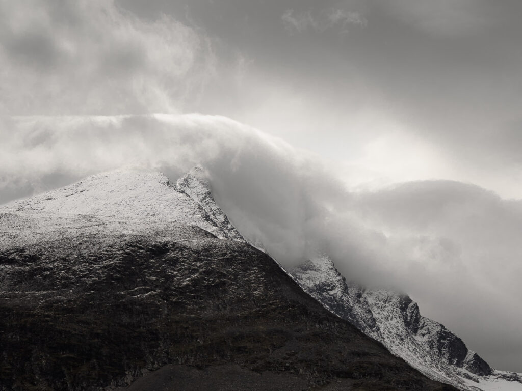 Clouds engulfing snow capped peaks, Jotunheimen, Norway